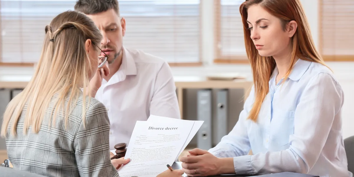 Couple in mediation meeting reviewing divorce documents