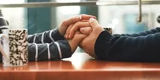 Couple holding hands across a table